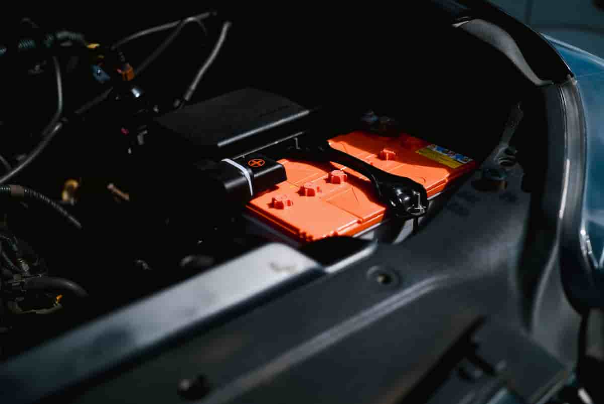New car battery being installed in an engine bay