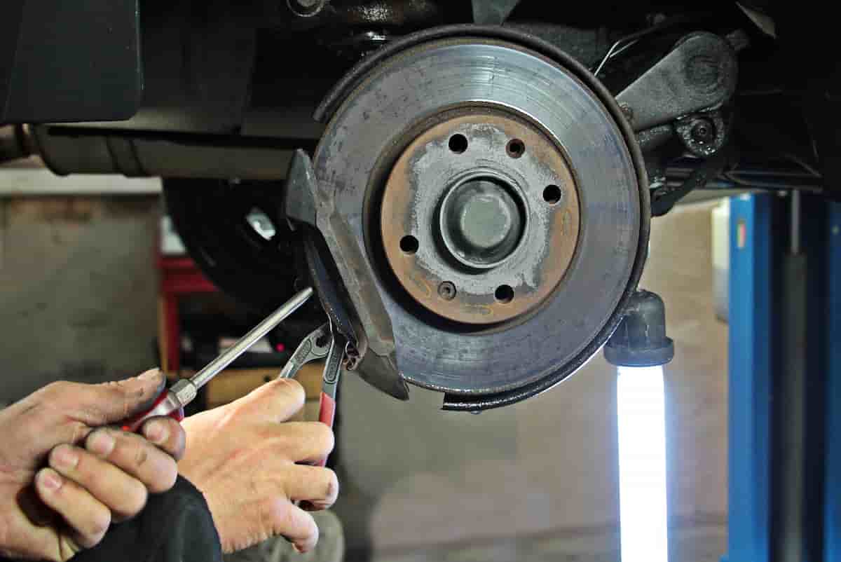 Brake rotor and caliper on a car raised on jack stands